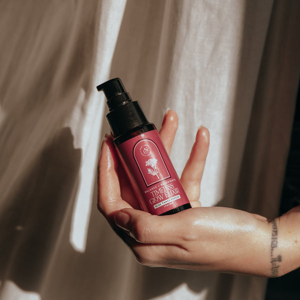 Candid Naturals Timeless Glow Elixir bottle held in hand