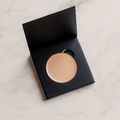 Candid Naturals Cream Concealer pan open in its compact showing a light neutral shade