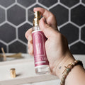Hand holding a bottle of Candid Naturals Revival Mist