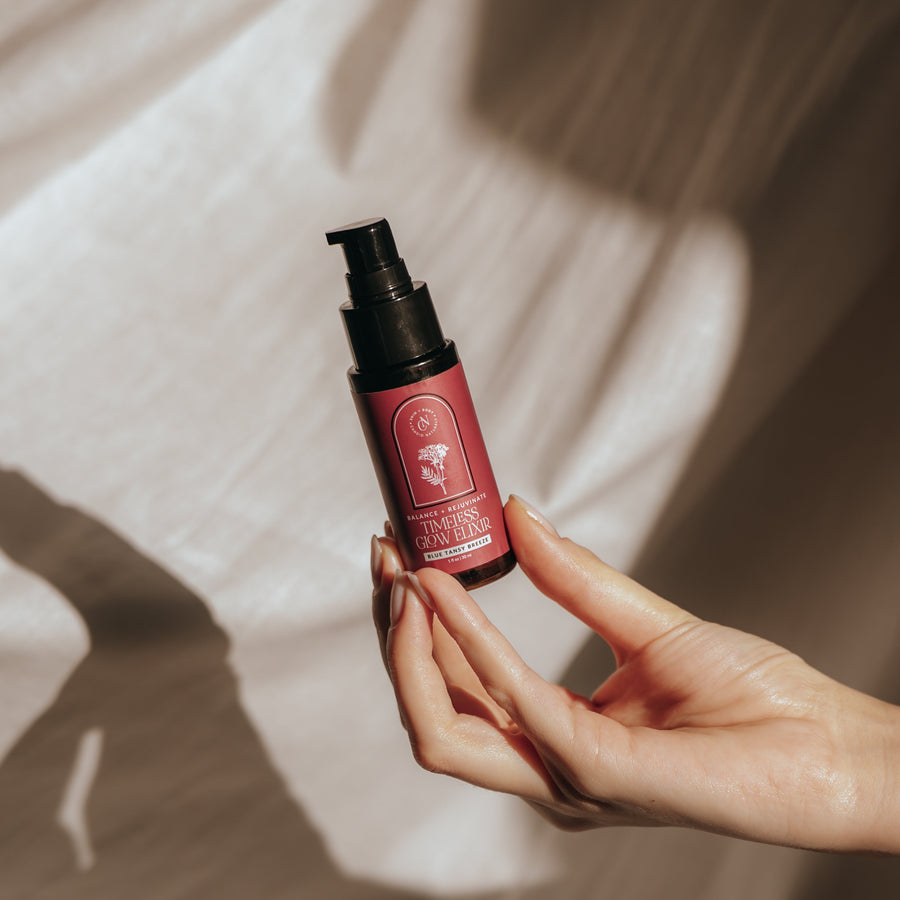 Hand holding a bottle of Candid Naturals Timeless Glow Elixir